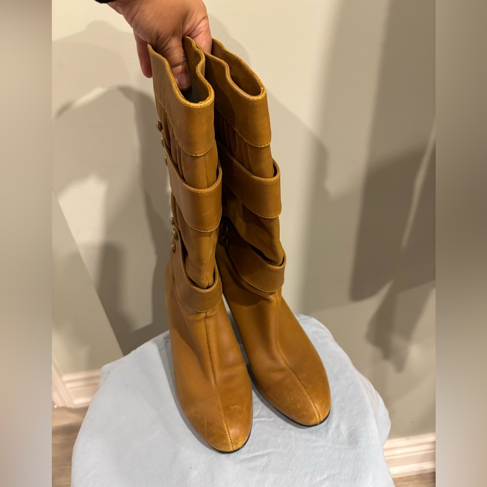 Heeled Tan leather knee-high boots with pleated details and studded buckles